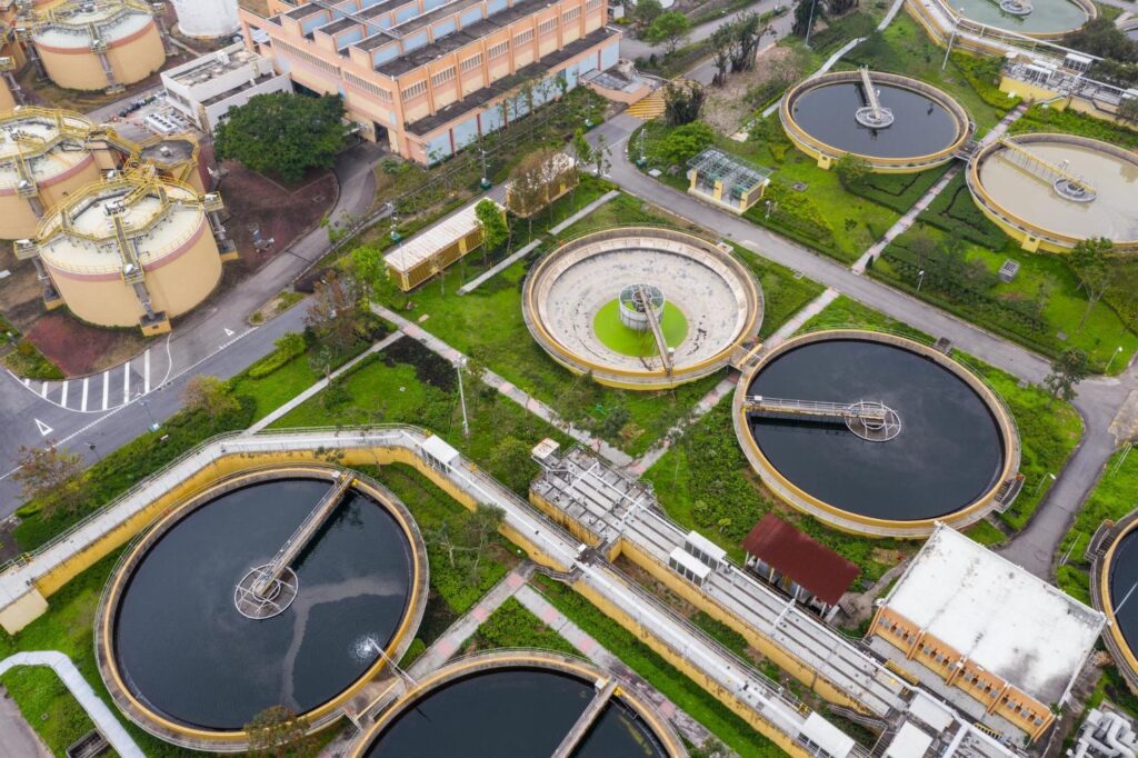Aerial view of an industrial wastewater treatment plant with circular tanks.
